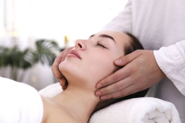 Masaj masasında uzanmış esmer bir kadın..