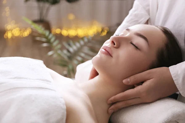Bruna femminile con espressione facciale rilassata sdraiata su un lettino da massaggio . — Foto Stock