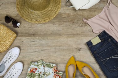 Sıradan moda arama kitabı konsepti. Ahşap kaplamalı arka planda giysi ve aksesuar parçaları ve metin için bir sürü kopya alanı. Üst manzara, düz yatak, yakın çekim..
