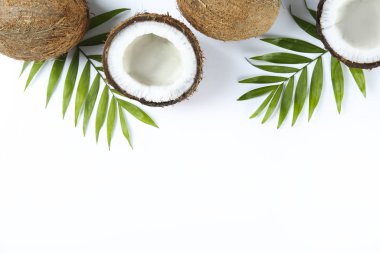 Hindistan cevizlerinin üst görüntüsü, kağıt üzerinde yarıya bölünmüş ve yarıya bölünmüş arka planda metin için bir sürü fotokopi alanı var. Tropik palmiye ağacının çiğ meyveli arka planı. Düz yatıyordu.