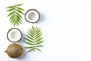 Hindistan cevizlerinin üst görüntüsü, kağıt üzerinde yarıya bölünmüş ve yarıya bölünmüş arka planda metin için bir sürü fotokopi alanı var. Tropik palmiye ağacının çiğ meyveli arka planı. Düz yatıyordu.