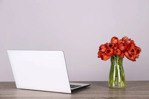 新鮮な花の組成 黒と白のラップトップコンピュータ 白い壁の背景とダーウィンハイブリッドチューリップの花束 オフィスロマンスの概念 コピースペース 閉じる 上のビュー フラットレイアウト — ストック写真