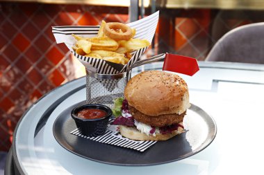 Nohut köfteli sebzeli burger, lahana turşusu, vejetaryen mayonezi ve yanında patates kızartması. Tabak servisi seçeneğiyle birlikte bedava fast food restoranı masası. Kapat, kopyala boşluk, arkaplan.