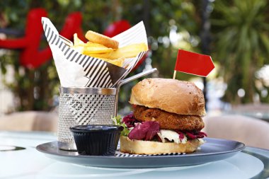 Nohut köfteli sebzeli burger, lahana turşusu, vejetaryen mayonezi ve yanında patates kızartması. Tabak servisi seçeneğiyle birlikte bedava fast food restoranı masası. Kapat, kopyala boşluk, arkaplan.