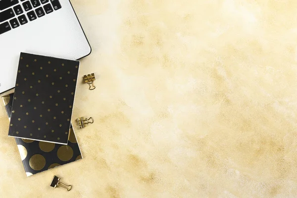 Cropped shot of black and white laptop keyboard with stationery accessories. Workspace of designer concept. Grunged stone background. Top view, flat lay, copy space.