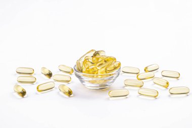 Omega 3 balık karaciğer yağı kapsülleri küçük cam kase içinde bir grup. Yığın altın yarı saydam hap kapatın. Her gün sağlıklı beslenme yağ asitleri dozaj ek. Üstten görünüm, düz yatıyordu, kopya alanı.