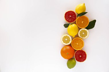 Sulu organik bir bütünün ve yarılanmış narenciye meyveleri, yeşil yapraklar ve görünür çekirdek dokusu, izole edilmiş beyaz arka plan, kopyalama alanı görüntüsünü kapat. C vitamini dolu gıda konsepti. Üst manzara, düz uzanma.