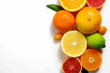 Sulu organik bir bütünün ve yarılanmış narenciye meyveleri, yeşil yapraklar ve görünür çekirdek dokusu, izole edilmiş beyaz arka plan, kopyalama alanı görüntüsünü kapat. C vitamini dolu gıda konsepti. Üst manzara, düz uzanma.