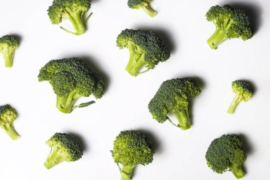 Temiz yeme konsepti. Bir grup olgun sulu taze koparılmış organik brokoli kafalar, beyaz arka planda izole edilmiş yeşil kaymak. Bahar detoksu için sağlıklı diyet. Çiğ vejetaryen yemeği. Kapat..
