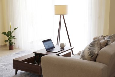 Merkez ofis konsepti. Oturma odasındaki çalışma alanından. Modern laptop ve bir fincan sıcak içecek ahşap masada. Kapat, kopyala boşluk, arkaplan.