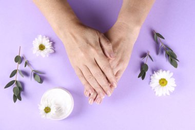 Aşırı sabun ve dezenfektan kullandıktan sonra iyileşme ve iyileşme için el kreminin canlandırılması. Yetişkin bir kadın nemlendirici losyon sürüyor. Boşluğu kopyala, kapat, arkaplan, düz alan, üst görünüm.