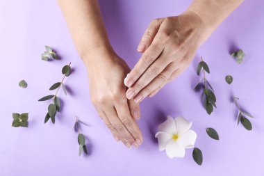 Aşırı sabun ve dezenfektan kullandıktan sonra iyileşme ve iyileşme için el kreminin canlandırılması. Yetişkin bir kadın nemlendirici losyon sürüyor. Boşluğu kopyala, kapat, arkaplan, düz alan, üst görünüm.