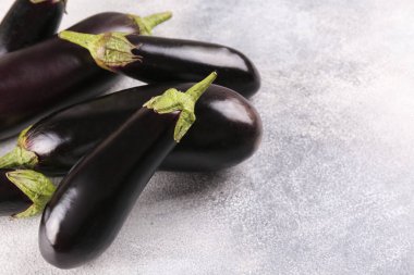 Bir grup olgun organik cilalanmış patlıcan grunted taş zemin üzerine konulmuş. Masada patates sebzesi var. Temiz yeme konsepti. Arkaplan, kapat, düz yat, üst manzara.