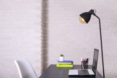 Bir blogcunun yaratıcı çalışma alanı. Beyaz dizüstü bilgisayar, ahşap masada, çatı katı tarzı, tuğla duvarlı. Tasarımcının masa konsepti. Kapat, kopyala boşluk, arkaplan.