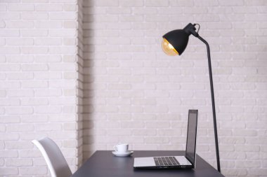 Bir blogcunun yaratıcı çalışma alanı. Beyaz dizüstü bilgisayar, ahşap masada, çatı katı tarzı, tuğla duvarlı. Tasarımcının masa konsepti. Kapat, kopyala boşluk, arkaplan.