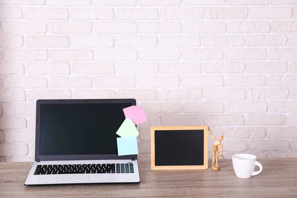 Creative workspace of a blogger. White laptop computer on wooden table in loft style office with brick walls. Designer\'s table concept. Close up, copy space, background.