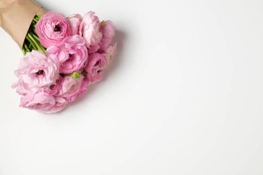 Görünür taç yaprağı desenli soluk pembe ranunculus çiçeklerinden oluşan güzel bir buket stüdyo resmi. Parlak çiçek tomurcukları ile yakın kompozisyon. Üst görünüm, izole edilmiş, kopyalama alanı.