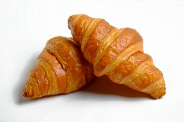 Beyaz arka planda izole edilmiş altın gevreğe pişirilmiş sade mini kruvasanın stüdyo çekimi. Geleneksel Fransız pastası. Kapat, boşluğu kopyala, üst görünüm.