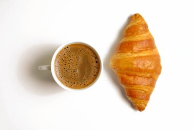 Altın gevreğe pişirilmiş mini kruvasan ve beyaz arka planda izole edilmiş bir fincan sade kahvenin stüdyo çekimi. Geleneksel Fransız pastası. Kapat, boşluğu kopyala, üst görünüm.