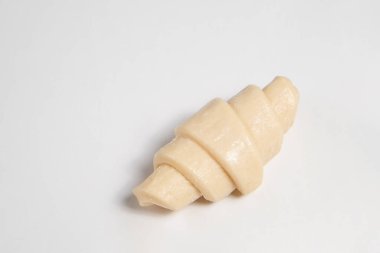 Beyaz arka planda izole edilmiş kruvasan pişirmeye hazır yarı donmuş halde stüdyo çekimini kapat. Pişmemiş geleneksel Fransız pastası. Boşluğu kopyala, üst görünüm.