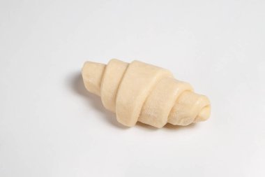 Beyaz arka planda izole edilmiş kruvasan pişirmeye hazır yarı donmuş halde stüdyo çekimini kapat. Pişmemiş geleneksel Fransız pastası. Boşluğu kopyala, üst görünüm.