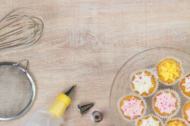 Renkli çörekler ve ahşap masa arka plan üzerinde pişirme araçları.