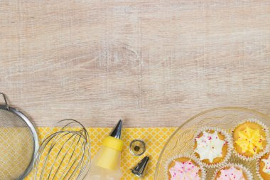 Renkli çörekler ve ahşap masa arka plan üzerinde pişirme araçları.