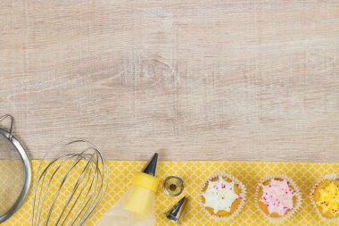 Renkli çörekler ve ahşap masa arka plan üzerinde pişirme araçları.