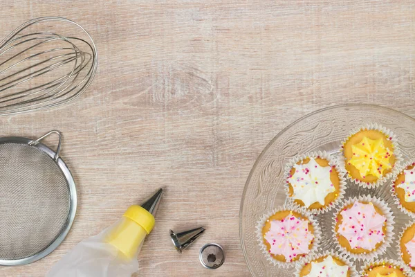 Renkli çörekler ve ahşap masa arka plan üzerinde pişirme araçları.