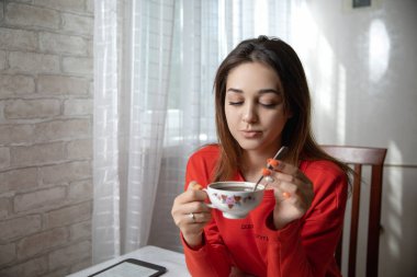 Mutfaktaki masada dijital kitap okuyan bir kız.