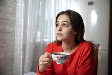 Mutfaktaki masada dijital kitap okuyan bir kız.