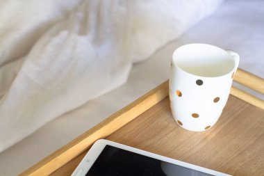 Dijital tablet teknolojisi ve yatakta kahve
