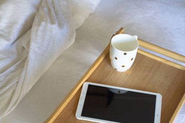Dijital tablet teknolojisi ve yatakta kahve