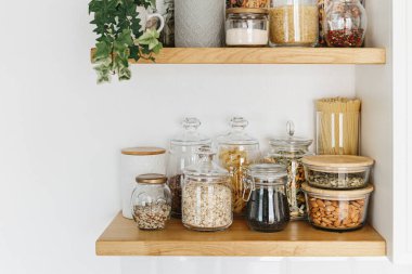 Mutfaktaki raflarda cam kavanozlarda çeşitli tahıl ve tohumlar var. Mutfak dahili fikirleri. Çevre dostu mutfak, sıfır atık ev konsepti