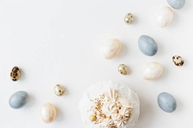 Beyaz desenli arka planda çiçekler ve renkli yumurtalarla süslenmiş jöleli paskalya pastası. Mutlu Paskalyalar. Üst görünüm