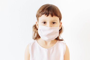 Kafkasyalı küçük kız beyaz arka planda yeniden kullanılabilir kumaş yüz maskesi takıyor. Çevre dostu maske. Güvende kal ve atık kavramını küçült