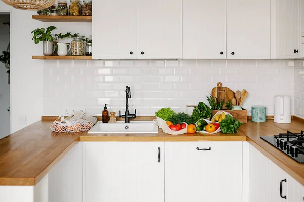 Taze sebzeler ve meyveler eko pamukta yeniden kullanılabilir poşetler mutfakta ahşap masada. sıfır atık alışveriş konsepti. Sürdürülebilir yaşam