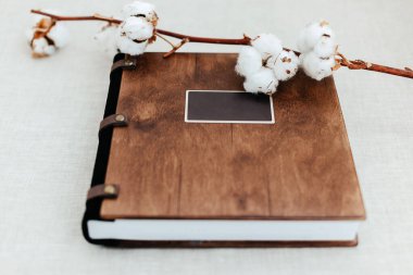 Doğal keten arka plan üzerine lüks ahşap fotoğraf kitabı. Aile anıları fotobook. Yaz tatili anılarını kendine sakla. Ahşap kapaklı fotoğraf albümü..