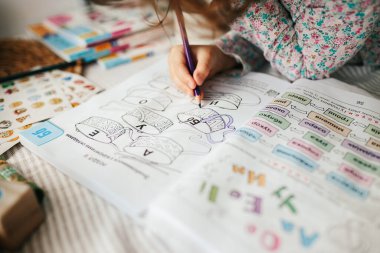 Sevimli beş yaşında bir kız evde öğreniyor. Çocuklar için eğitim ve uzak mesafe eğitimi. Evde eğitim kavramı