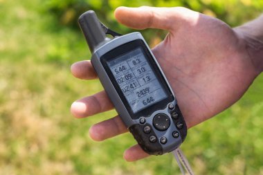 GPS izci elinde yeşil bir arka plana dayanır