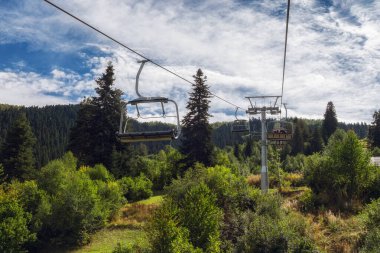 Güneşli bir sonbahar gününde dağ ormanının üstündeki füniküler koltuktan manzara