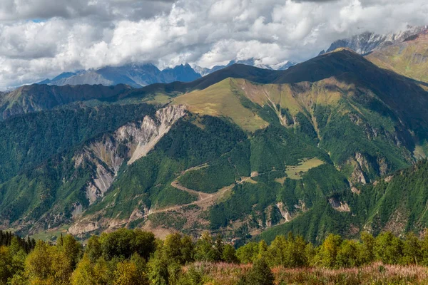 Montañas y prado verde con árboles vistos desde la estación de esquí de Hatsvali en un día soleado de otoño en Svaneti Georgia — Foto de Stock