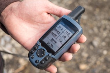 Turist el ele tutuşmuş eski GPS takip cihazı üzerinde bazı veriler var.