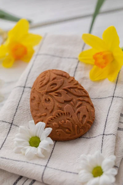 Easter egg shaped gluten free ginger cookies on the kitchen towel background, selective focus