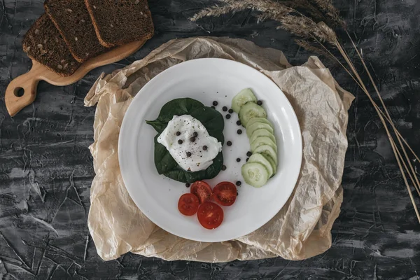 Haşlanmış yumurta, salatalık, vişneli domates ve ıspanakla kahvaltı.