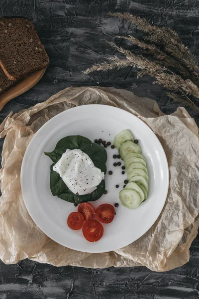 Haşlanmış yumurta, salatalık, vişneli domates ve ıspanakla kahvaltı.