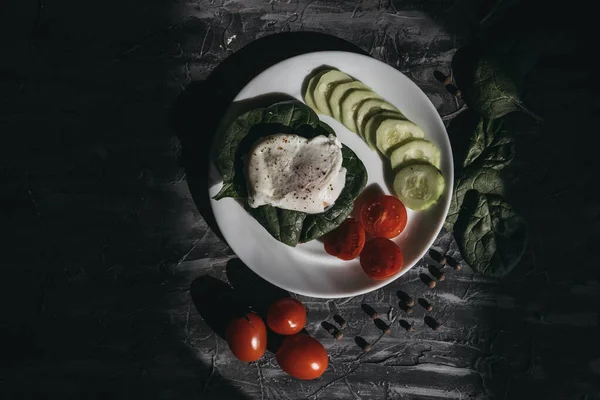 Haşlanmış yumurta, salatalık, vişneli domates ve ıspanakla kahvaltı.