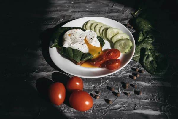 Haşlanmış yumurta, salatalık, vişneli domates ve ıspanakla kahvaltı.