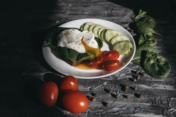 Haşlanmış yumurta, salatalık, vişneli domates ve ıspanakla kahvaltı.
