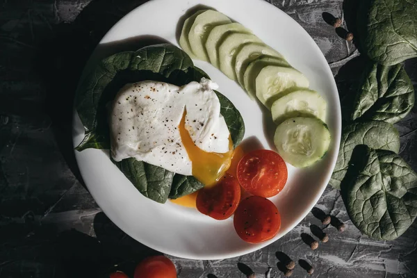 Haşlanmış yumurta, salatalık, vişneli domates ve ıspanakla kahvaltı.